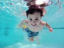 Photograph of a child swimming. Photo was taken underwater.